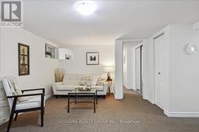 Mississauga (Mineola) multi-family for rent - A living room with a white couch and a wooden chair.