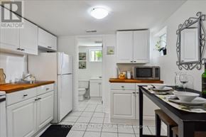 Mississauga (Mineola) multi-family for rent - A kitchen with white cabinets and a wooden countertop.