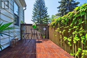 Mississauga (Mineola) multi-family for rent - A wooden deck with a gate and a tree in the background.