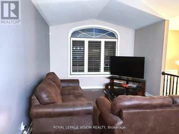 Niagara Falls (Ascot) apartment for rent - A living room with a brown leather couch and a flat screen TV.