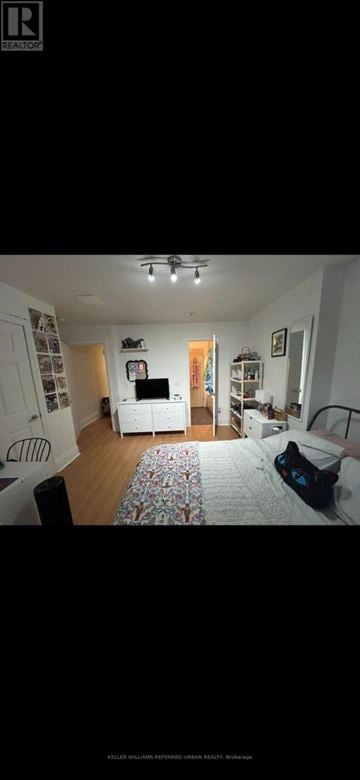Toronto (University) triplex for rent - A living room with a white couch and a television.