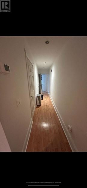 Toronto (University) triplex for rent - A long hallway with a door on the left and a window on the right.