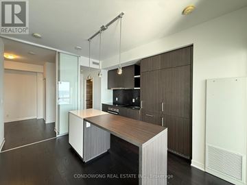 Toronto (Waterfront Communities) condo for rent - A modern kitchen with a wooden island and stainless steel appliances.