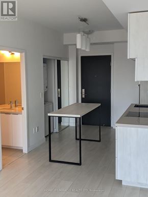 Toronto (Yonge-Eglinton) condo for rent - A modern kitchen with a table and chairs in the middle of the room.