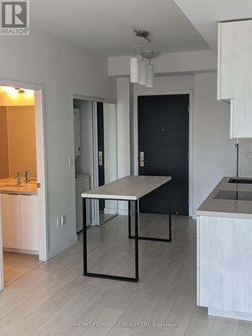 Toronto (Yonge-Eglinton) condo for rent - A modern kitchen with a table and chairs in the middle of the room.