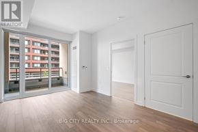 Vaughan condo for rent - A room with a white door and a window with a view of a building across the street.