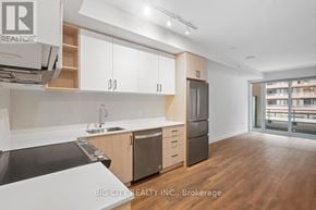 Vaughan condo for rent - A modern kitchen with wooden floors and white cabinets.