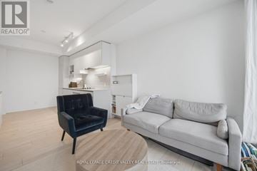 Vaughan (Vaughan Corporate Centre) condo for rent - A living room with a black chair and a grey couch.