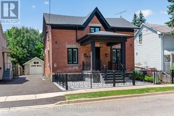 Brampton (Downtown Brampton) apartment for rent - A red brick house with a black iron fence in front.