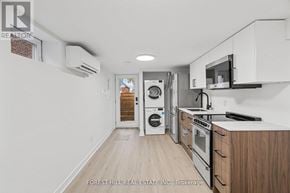 Toronto (Beechborough-Greenbrook) apartment for rent - A kitchen with white cabinets and a microwave above the stove.
