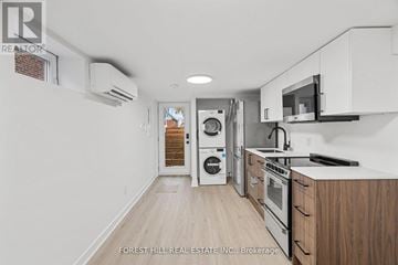 Toronto (Beechborough-Greenbrook) apartment for rent - A kitchen with white cabinets and a microwave above the stove.