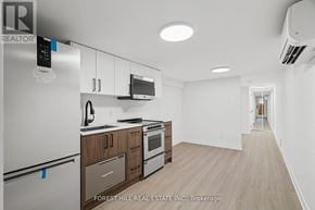 Toronto (Beechborough-Greenbrook) apartment for rent - A kitchen with a refrigerator, microwave, oven and cabinets.