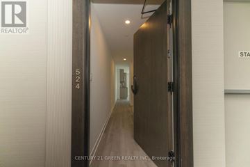 Oakville (Jm Joshua Meadows) condo for rent - A hallway with a door on the left and a sign on the right.