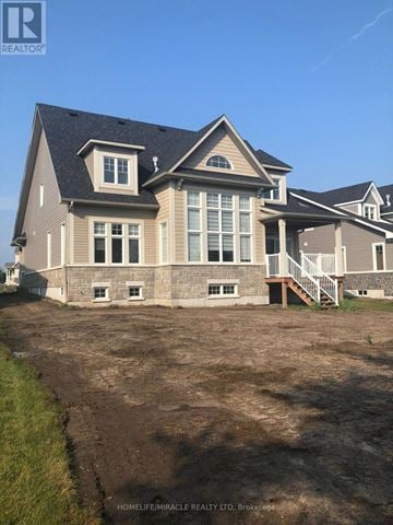 Loyalist (Bath) apartment for rent - A large house with a grey roof and a balcony is situated on a plot of land.
