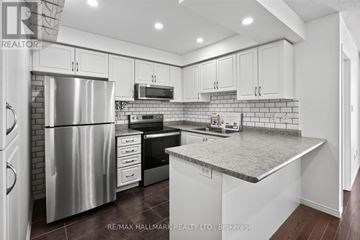 Ajax (Central East) townhouse for rent - A kitchen with white cabinets and a stainless steel refrigerator.