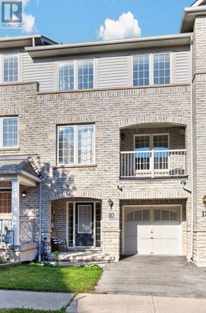 Ajax (Central East) townhouse for rent - A grey building with a balcony and a white door.