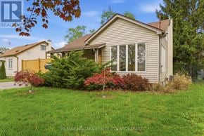 Welland (Broadway) apartment for rent - A house with a well-kept lawn and a tree with red leaves in front.