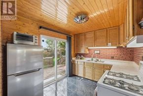 Welland (Broadway) apartment for rent - A kitchen with wooden cabinets and a brick wall.