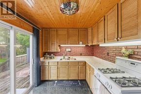 Welland (Broadway) apartment for rent - A kitchen with wooden cabinets and a brick backsplash.