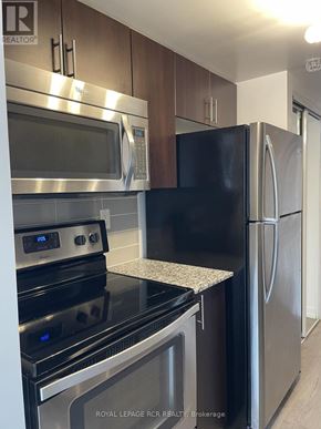 Toronto (Dovercourt-Wallace Emerson-Junction) condo for rent - A kitchen with a stove top oven and a refrigerator.