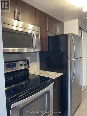 Toronto (Dovercourt-Wallace Emerson-Junction) condo for rent - A kitchen with a stove top oven and a refrigerator.