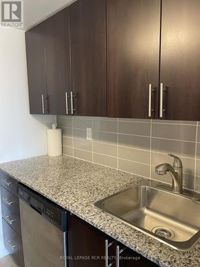 Toronto (Dovercourt-Wallace Emerson-Junction) condo for rent - A kitchen with brown cabinets and a granite counter top.