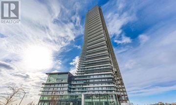 Mississauga (City Centre) condo for rent - A tall, modern building with a glass facade and a unique curved design.