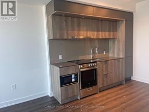 Mississauga (City Centre) condo for rent - A modern kitchen with wooden cabinets and stainless steel appliances.