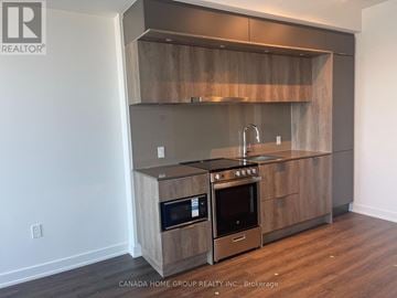Mississauga (City Centre) condo for rent - A modern kitchen with wooden cabinets and stainless steel appliances.