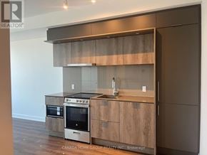 Mississauga (City Centre) condo for rent - A modern kitchen with wooden cabinets and stainless steel appliances.