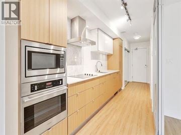 Vancouver apartment for rent - A modern kitchen with wooden cabinets and stainless steel appliances.