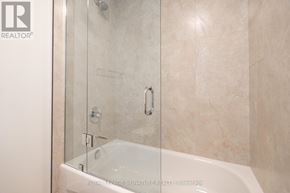 Toronto (Oakwood Village) multi-family for rent - A white bathtub with a glass shower door in a bathroom.