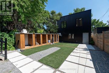 Toronto (Oakwood Village) multi-family for rent - A modern black house with a gravel and grass yard.
