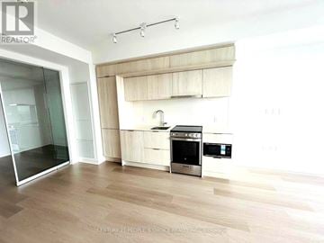 Mississauga (City Centre) condo for rent - A modern kitchen with wooden cabinets and stainless steel appliances.