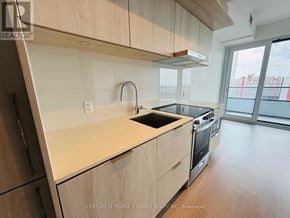 Mississauga (City Centre) condo for rent - A kitchen with wooden cabinets and a black stove top oven.