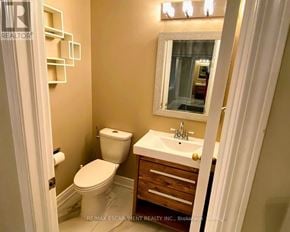 Mississauga (Lisgar) apartment for rent - A bathroom with a toilet, sink, and mirror.