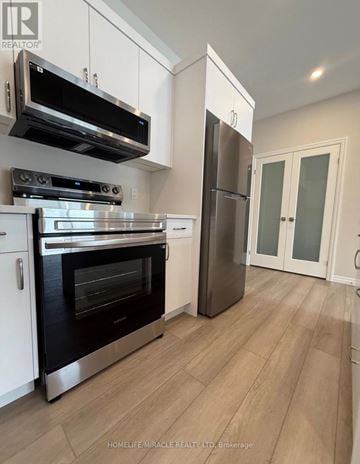 Tillsonburg townhouse for rent - A kitchen with a stainless steel refrigerator and oven.
