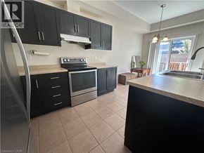 Grimsby townhouse for rent - A kitchen with black cabinets and a stainless steel refrigerator.