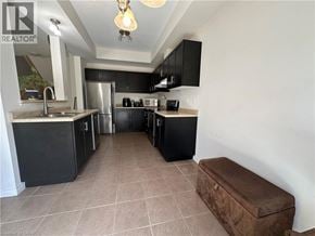 Grimsby townhouse for rent - A kitchen with black cabinets and a refrigerator.