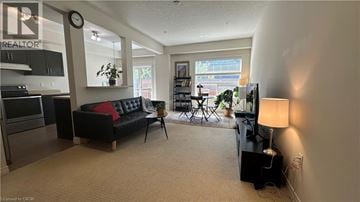 Grimsby townhouse for rent - A living room with a black couch and a lamp.