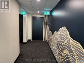 Markham (Unionville) condo for rent - A hallway with a wall mural and two green exit signs.