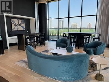 Markham (Unionville) condo for rent - A living room with a large blue couch and a painting on the wall.