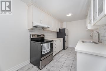 Brampton (Central Park) apartment for rent - A kitchen with white cabinets and black appliances.