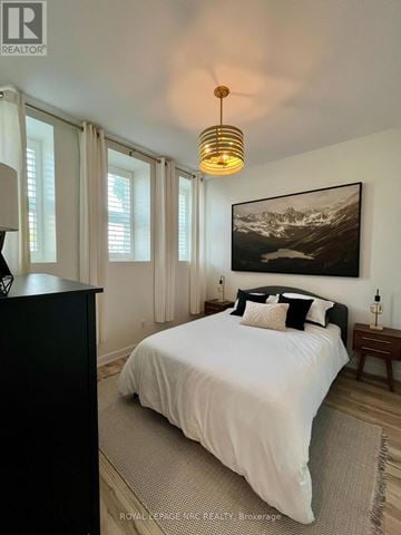 St. Catharines (Oakdale) condo for rent - A bedroom with a large bed and a painting on the wall.