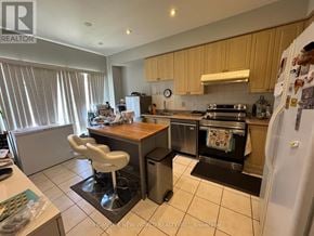 Toronto (Newtonbrook West) townhouse for rent - A kitchen with a refrigerator, sink, and stove.
