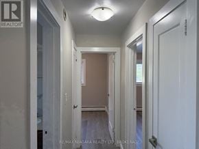 St. Catharines (Carlton/Bunting) condo for rent - A hallway with white walls and a light on the ceiling.