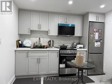 Ajax (Central) apartment for rent - A kitchen with white cabinets and a stainless steel refrigerator.