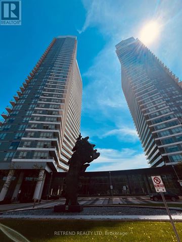 Toronto (Bayview Village) condo for rent - A tall building with a glass facade stands next to a smaller building with a similar design.