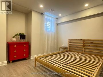 Markham (Berczy) apartment for rent - A bedroom with a red dresser and a wooden bed.