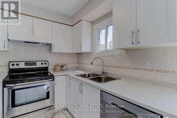 Oakville (Wc Wedgewood Creek) apartment for rent - A kitchen with white cabinets and a stove top oven.